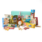 Sfeerbeeld van het Aperitiefgeschenk ‘Sunset Sip’ met losse nootjes en zoute snacks naast de doos